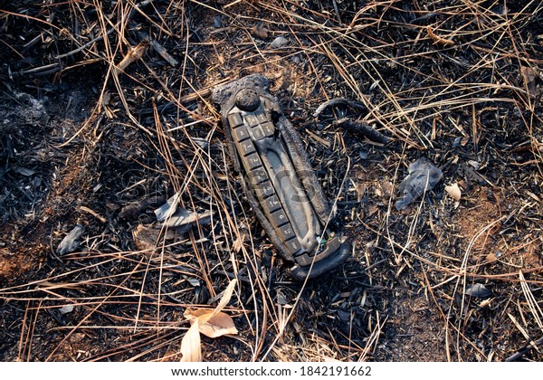 Burnt car\
radio on the ground after forest\
fire.