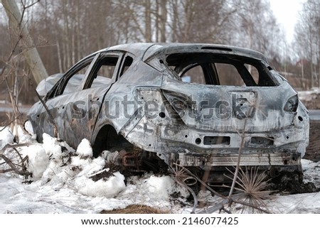 Burnt car with small flames inside of the engine. Burnt new car. malfunction that led to the death of the atomobile and people