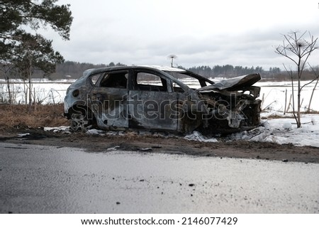 Burnt car with small flames inside of the engine. Burnt new car. malfunction that led to the death of the atomobile and people