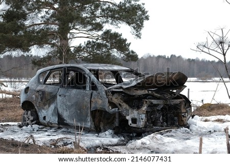 Burnt car with small flames inside of the engine. Burnt new car. malfunction that led to the death of the atomobile and people