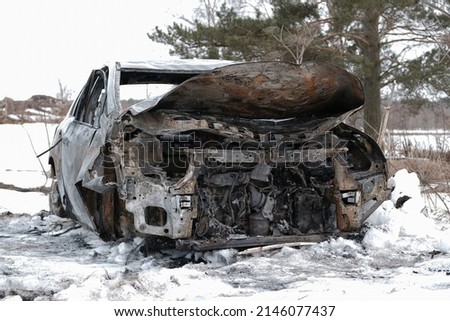 Burnt car with small flames inside of the engine. Burnt new car. malfunction that led to the death of the atomobile and people