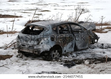 Burnt car with small flames inside of the engine. Burnt new car. malfunction that led to the death of the atomobile and people