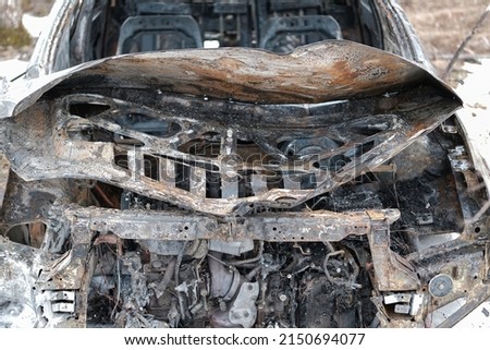 Burnt car with small flames inside of the engine. Burnt new car. malfunction that led to the death of the atomobile and people, soft focus, selective focus