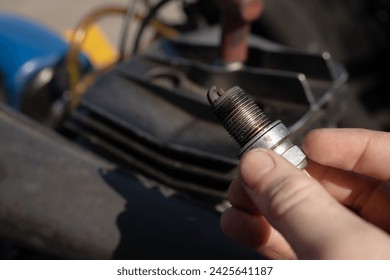 burnt car spark plug in the hands of a mechanic. Automotive children's sports
