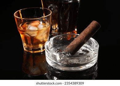 Burnt cigar, ashtray and whiskey on black mirror surface, closeup - Powered by Shutterstock