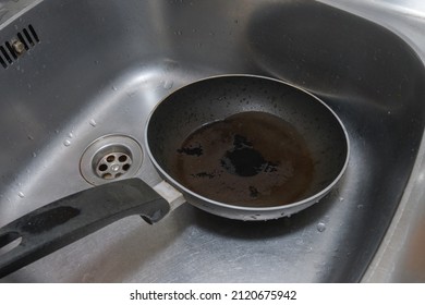 Burnt Frying Pan In The Kitchen Sink. Close-up