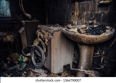 Burnt House Interior. Burned Burnt Bathroom, Fused Remains Of Furniture And Washing Machine.