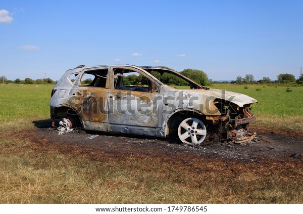 Burnt out car in field. Stolen car dumped in\
agricultural area