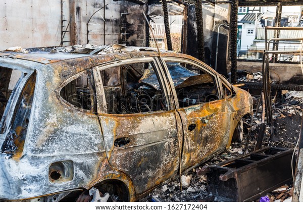 Burnt out car in a garage - police-secured crime\
scene - forbidden to\
enter