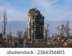 A burnt - out high - rise in a combat zone in the city of Mariupol . Damage to a residential building. The war in residential areas, broken windows and burned apartments. Armed conflict in Ukraine