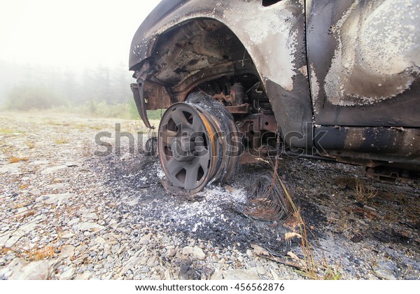 Burnt out truck left abandoned on common ground.\
This is the remains of the car wheel after the tyre has been burnt\
to nothing
