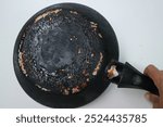 Burnt pan. Back of a charred frying pan. the bottom of the frying pan is black and charred.