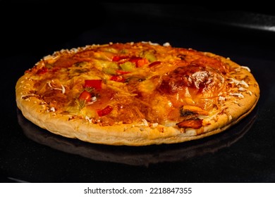 Burnt Pizza With Sausage, Mushroom, Pepper, Mozzarella On Tray In Electric Oven, Black Background. Italian Cuisine, Homemade Bakery, Fast Food Concept