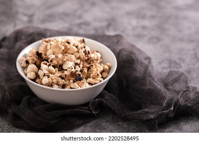 Burnt Popcorn In The Small White Bowl On Grey Ceramic