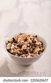 Burnt Popcorn In The Small White Bowl On Grey Ceramic