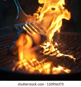 Burnt Sausages Being Flipped In A BBQ Flame