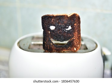 Burnt Toast With An Angry Face Expressing The Emotion Of Sadness Or Sarcasm. Burnt Toast Bread Slices Out Of A Toaster. Сoncept Of Unsuccessful Breakfast Preparation Before A Work Day Or Weekend