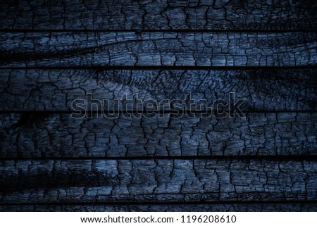 Burnt wooden Board texture. Burned scratched hardwood surface. Smoking wood plank halloween background