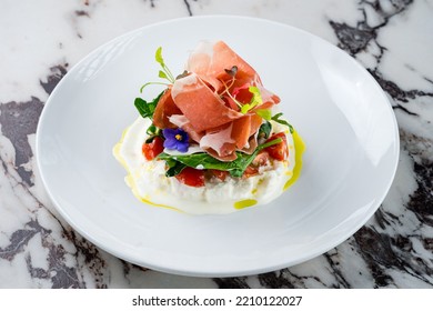 Burrata Cheese With Italian Delicatessen Salad With Parma Ham Slices On White Plate. Burrata With Parma Ham