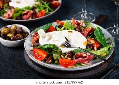 Burrata, Italian fresh cheese made from cream and milk of buffalo or cow. Burrata salad with tomatoes and salad mix. Healthy eating concept. Keto diet salad. - Shutterstock ID 2117999762