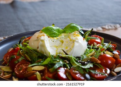 
Burrata Salad with Cherry Tomatoes, Rucola, Basil, Olive Oil and Balsamic Creme. Burrata fresh cheeses tastes amazing and can be served alongside tomatoes, grilled bread, or vegetables. - Powered by Shutterstock