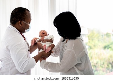 Burred Soft Images Of Mother Is Holding A 12-day-old Baby Newborn Son, Sent To An African Doctor Which Wearing A Surgical Mask, For A Health Check, To Baby And Health Care Concept.