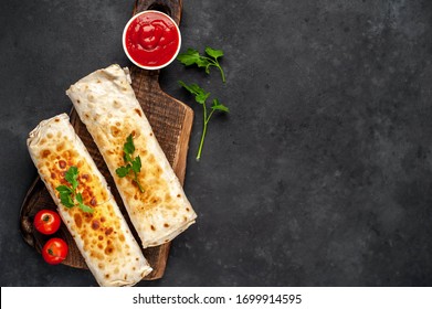 Burrito wraps with chicken and vegetables , against a background of concrete 
with copy space for your text, 
Mexican shawarma