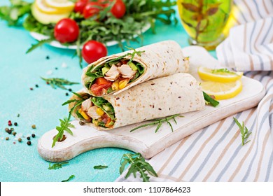 Burritos wraps with chicken and vegetables on light  background. Chicken burrito, mexican food.