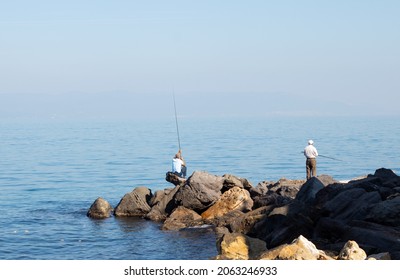 Bursa, Turkey - October 2021: Fishing Activity, Two Old Men Fishing From Top Of The Rocks, Peaceful And Clear Sky Scene, Selective Focus