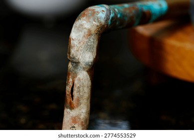 Burst copper pipe showing split plumbing damage from freezing, water leak repair, and household emergency maintenance.