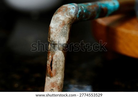 Burst copper pipe showing split plumbing damage from freezing, water leak repair, and household emergency maintenance.