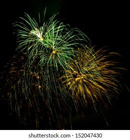 Bursts Of Green And Gold Fireworks Against A Black Sky