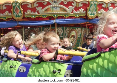 BURTON, OH - SEPT 5: Children Riding The Dinosaur Train, With Carousel In Background, At The 188th Annual Great Geauga County Fair On September 5, 2010 In Burton, Ohio.