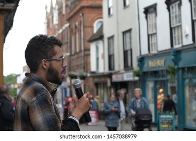 Bury St Edmunds, Suffolk, UK - July 2019: Busker Of Ethnic Minority On The High Street Singing While Shoppers Walk By