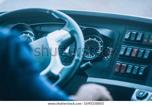 Bus driver, driving a bus or truck: view of\
the steering wheel and\
dashboard.