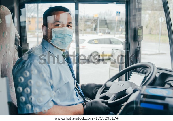 bus\
driver with mask wearing protecting gloves on his hand in bus to\
protect himself from the coronavirus epidemic. Pandemic coronavirus\
2020. Quarantine. Virus concept. Epidemic\
infection.