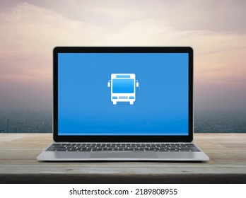 Bus Flat Icon On Modern Laptop Computer Monitor Screen On Wooden Table Over Office City Tower And Skyscraper At Sunset Sky, Vintage Style, Business Transportation Online Service Concept