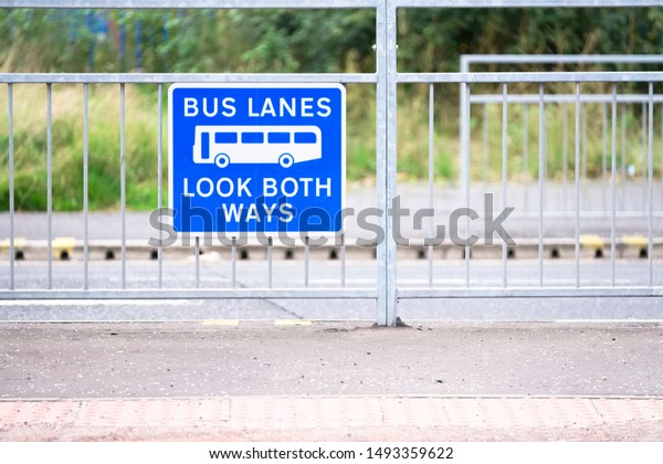 Bus lanes\
sign in city with look both ways\
warning