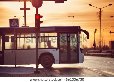 Bus moving on the road in city in early morning. View to the traffic with trafficlights and transport