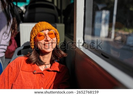 Bus passenger looking out the window. Public transport. Beautiful young woman going to work by bus.