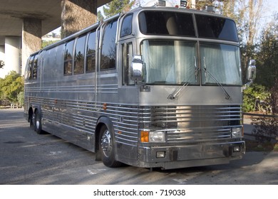 The Bus For A Rock Band Hides Below A Freeway Overpass.