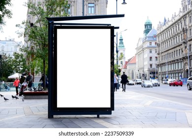 bus shelter with blank ad panel. billboard display. empty white lightbox sign at bus stop. billboard mockup. glass structure. city transit station. urban street. park setting. outdoor advertising.