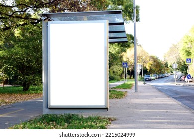 bus shelter with blank poster ad lightbox. bus transit stop. blank white billboard panel. glass structure. urban setting. city street. asphalt sidewalk. outdoor commercial space. background for mockup