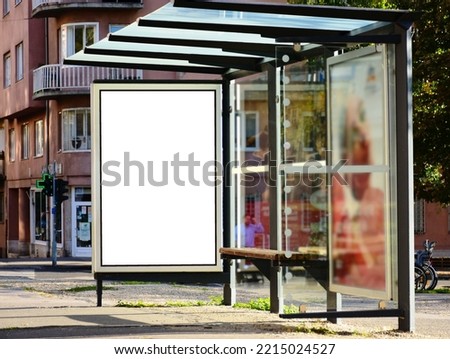 bus shelter with blank poster ad lightbox. bus transit stop. blank white billboard panel. glass structure. urban setting. city street. asphalt sidewalk. outdoor commercial space. background for mockup