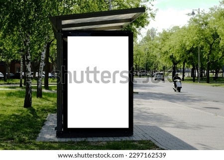 bus shelter at busstop. blank white lightbox. empty billboard. bus shelter ad. glass and aluminum structure. transit station. urban setting. city street background. stone sidewalk. base for mockup