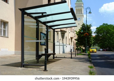 Bus Shelter And Bus Stop Along Urban Street. Glass And Aluminum Structure. City Street With Trees. Safety Glass Design. Poster And Ad Display Glass, Banner And Copy Space. Mockup Base.