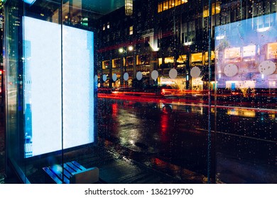 Bus Station Billboard In Rainy Night With Blank Copy Space Screen For Advertising Or Promotional Content, Empty Mock Up Lightbox For Information, Blank Display In Urban City Street With Long Exposure