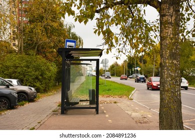 Bus stop with bench in city. Empty bus stop. Cars. Transport concept.  bus stop on city street. In the background  road. Mock up. Poster on street next to roadway. Sunny day.