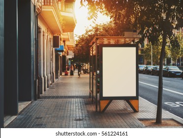 Bus Stop In City With Empty White Mock Up Banner For Advertising, Clear Public Information Board In Urban Setting In Sunny Summer Day, Blank Billboard With Copy Space Section For Informational Message