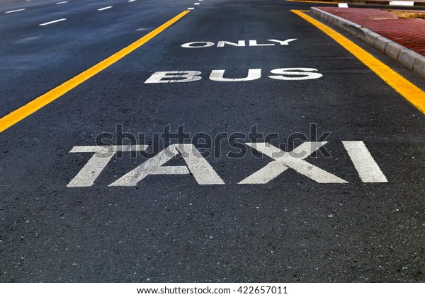 Bus and Taxi\
sign painted on street\
outdoors